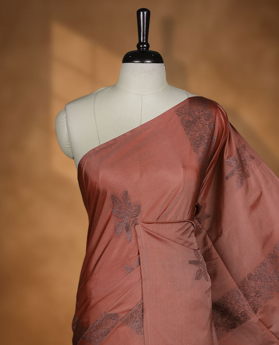Brick colour semi soft silk saree adorned with delicate woven floral kodi motifs on the body, complemented by a Self colour woven pallu with intricate detailing and tassel accents without border & Comes with a matching blouse piece.