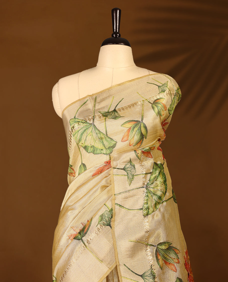Light gold colour Organza Kerala saree with a sheer, smooth body and soft golden sheen. Accented with a fine zari border and Lotus floral motifs near the pleats. Comes paired with a coordinated matching blouse.