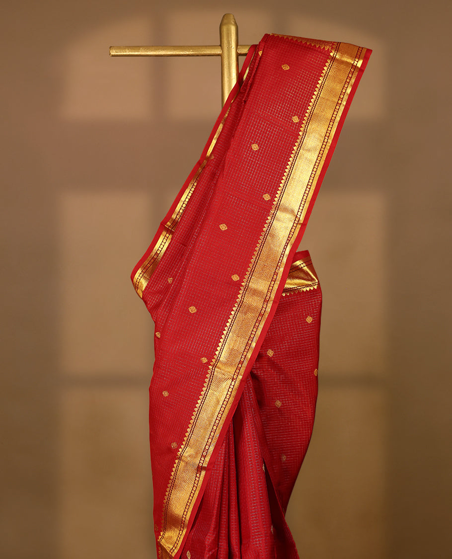 Red traditional Kancheepuram silk saree featuring antique zari check patterns with golden motifs on the body, a classic rudraksham border, and a matching blouse.