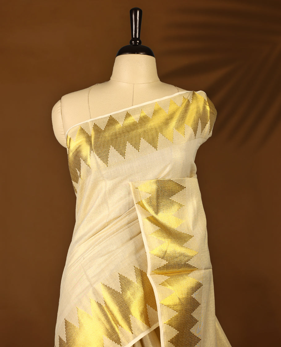 Light Gold colour Tissue Kerala saree featuring Plain body and a beautifully woven Gold Kasavu border with Diamond Patterns, paired with a matching blouse perfect for festive occasions.