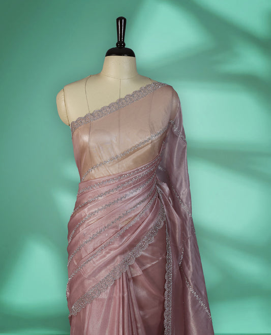 Pastel Pink colour net shimmer fancy saree adorned with subtle horizontal White stone patterns on the body, paired with a delicate stone worked border, with matching blouse