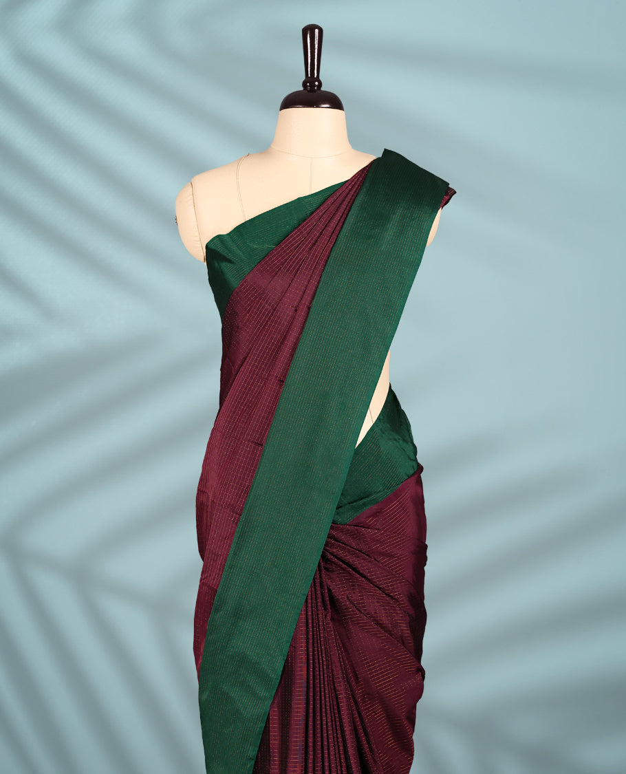 Deep Grape Colour semi silk saree features an elegant copper zari check pattern, complemented by a forest green border and a matching blouse