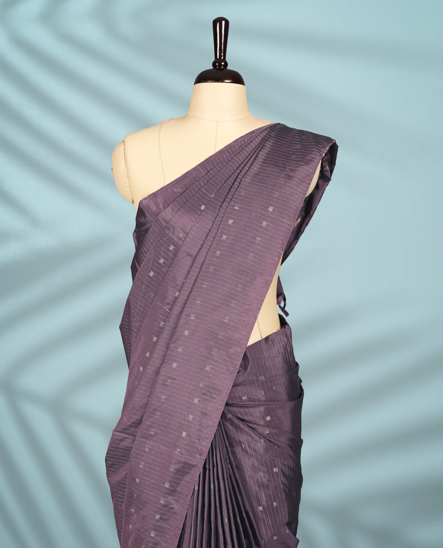 Mauve Colour semi silk saree features subtle square and stripe motifs across the body, comes without a border and paired with a matching blouse.
