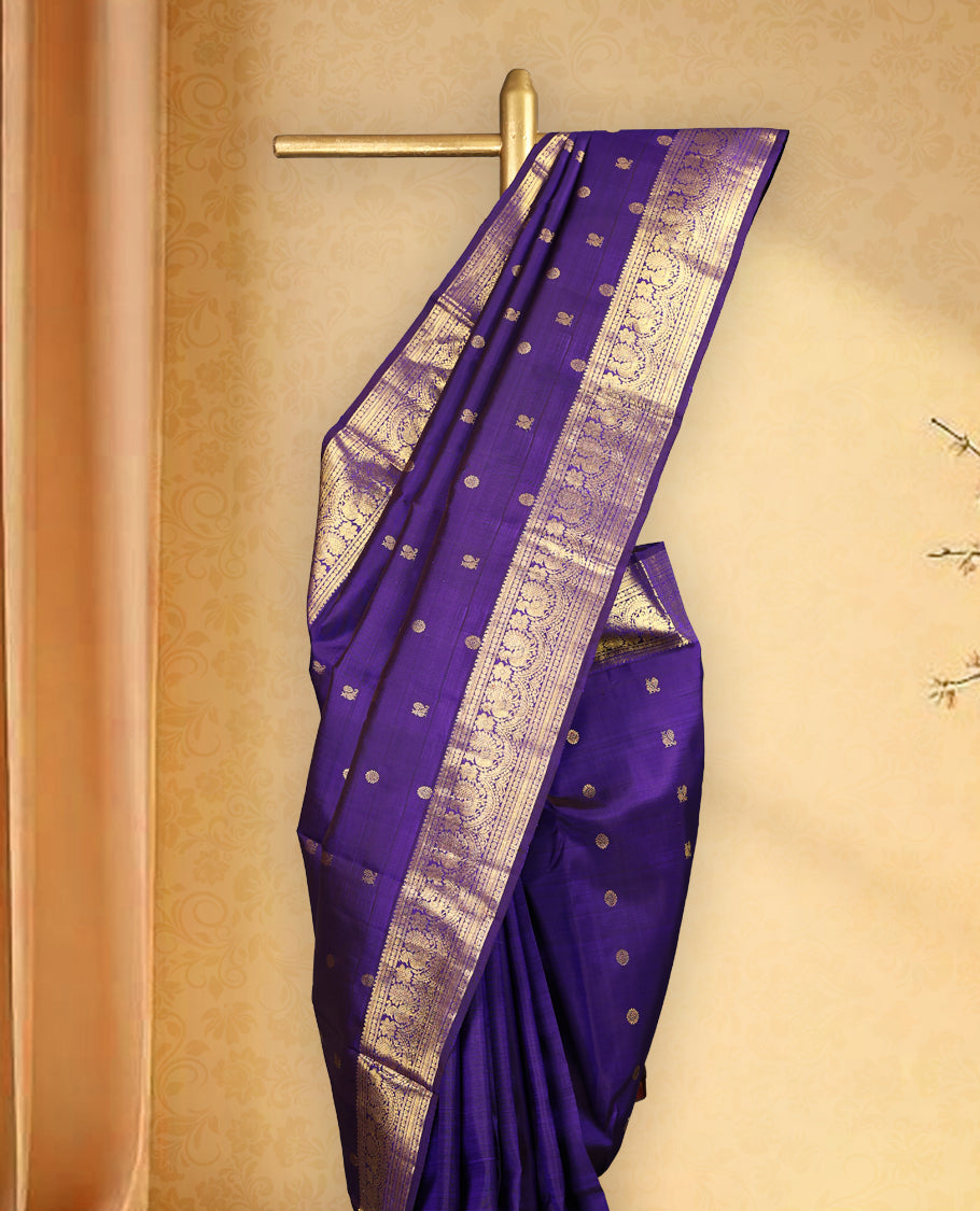 Deep violet colour pure Kancheepuram saree with gold zari Mayoora Chakra motifs on the body, traditional border featuring peacock and floral patterns, grand pallu, and paired with a matching blouse.