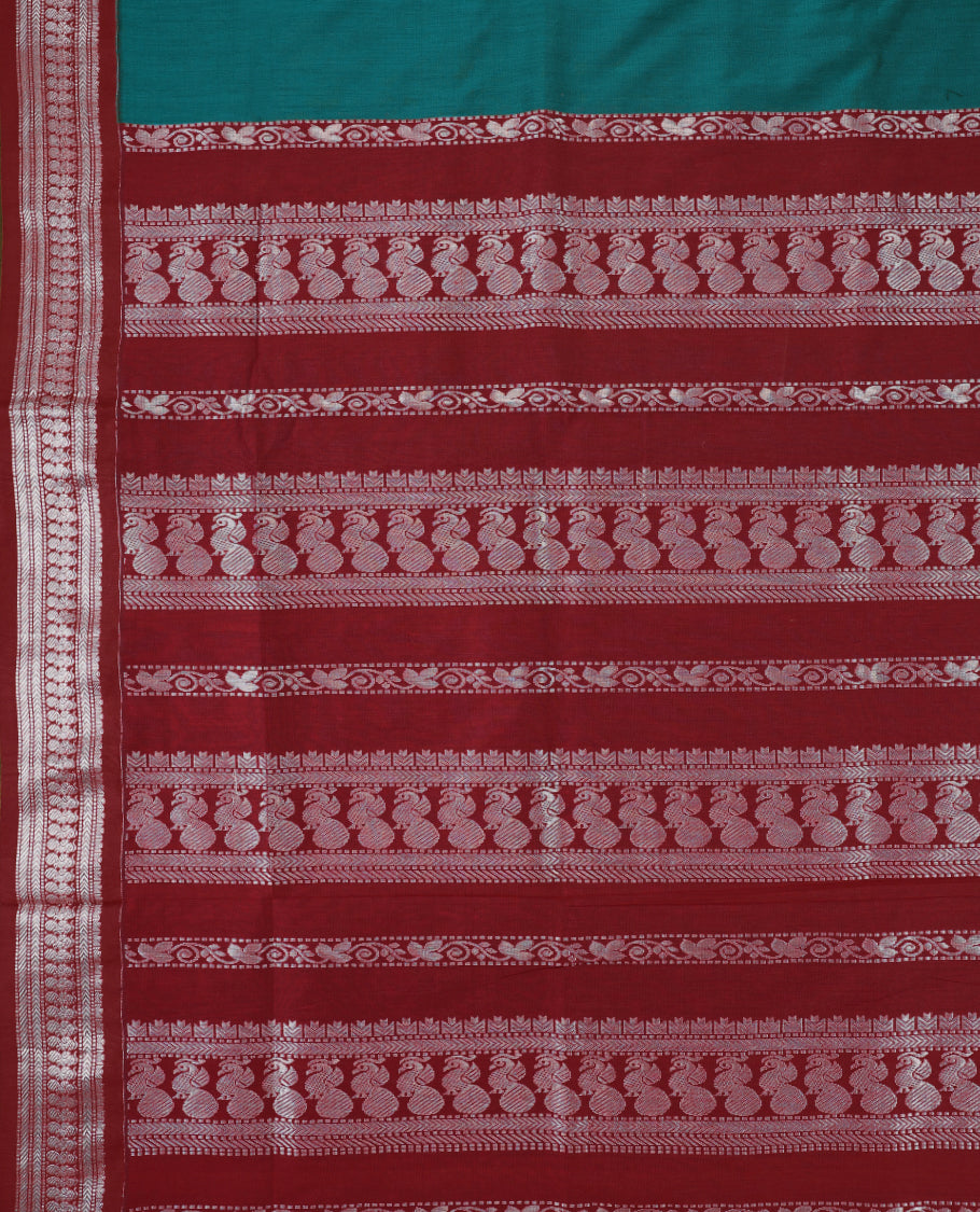 Peacock Blue colour mixed Kalyani cotton saree featuring Silver zari peacock motifs throughout the body, paired with a Maroon colour traditional border and pallu, with matching blouse