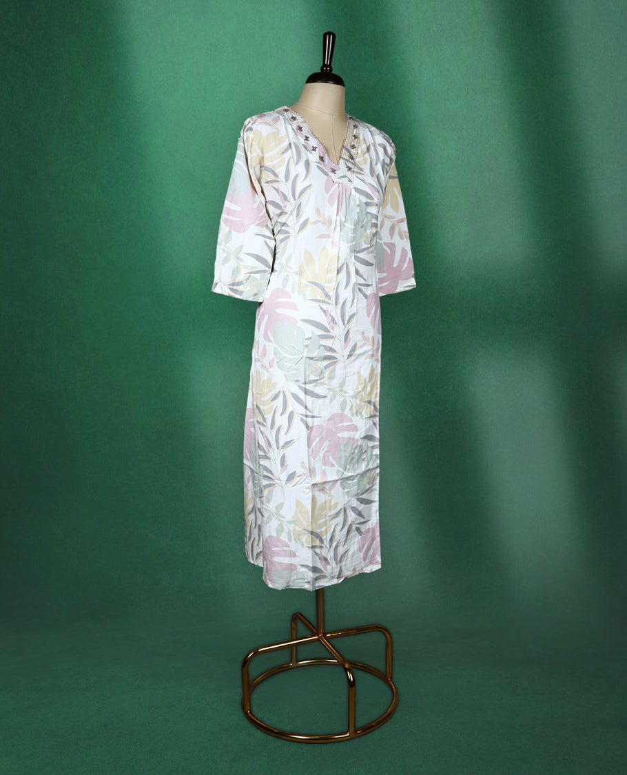 White colour kurti featuring pastel botanical prints in shades of pink, mint, and beige, designed with a V neckline embellished with delicate embroidery and finished with three quarter sleeves & soft, airy choice for effortless everyday wea