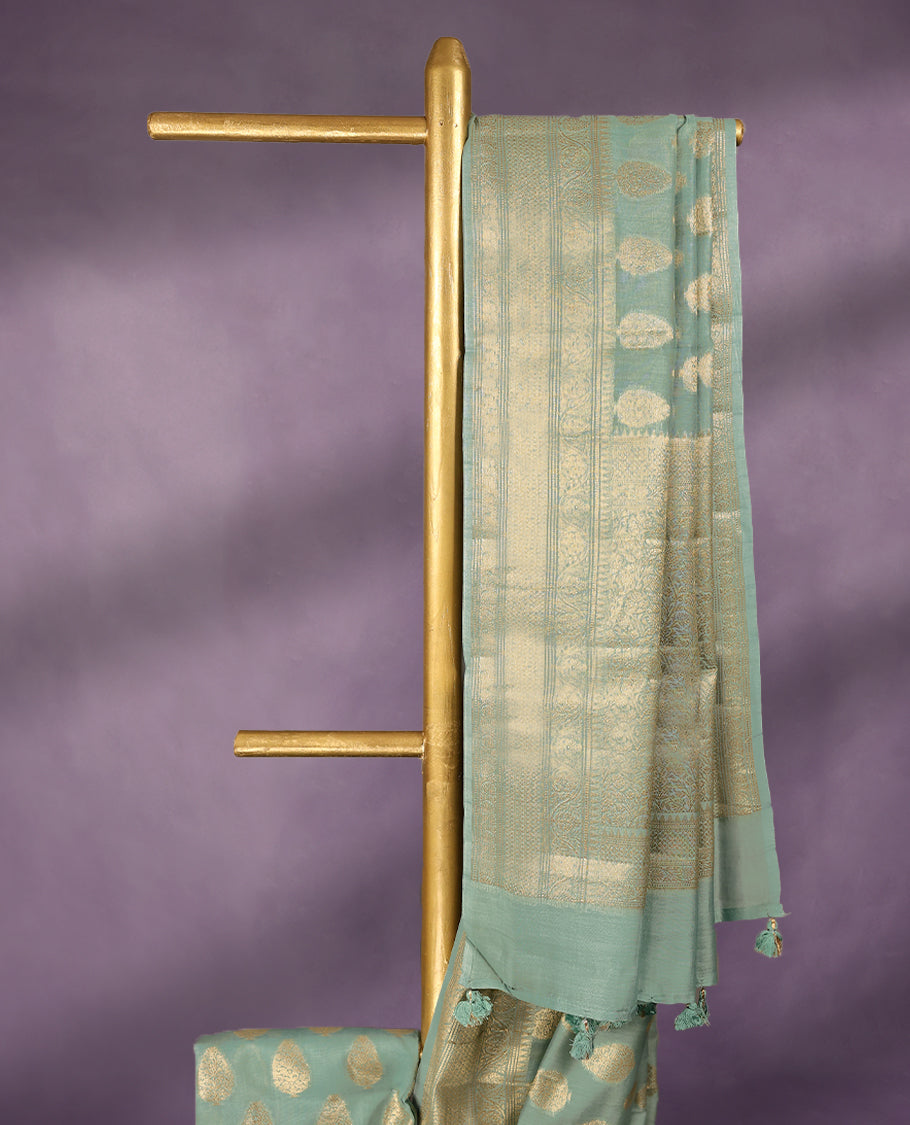 Light Aqua colour pure Banarasi Chanderi cotton, beautifully adorned with traditional antique zari Medium Butta designs across the body, completed with a hand-dyed colour, a traditional border, and a matching blouse.
