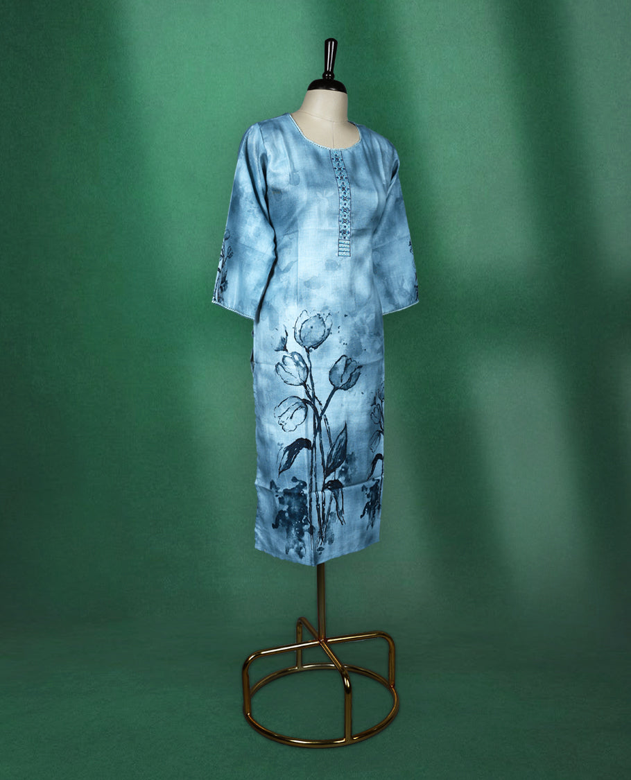 Light blue cotton kurti featuring a serene watercolour floral design near the hem and sleeves, complemented by a round neckline with vertical embroidery detail and three quarter sleeves, graceful pick for a relaxed yet refined look.