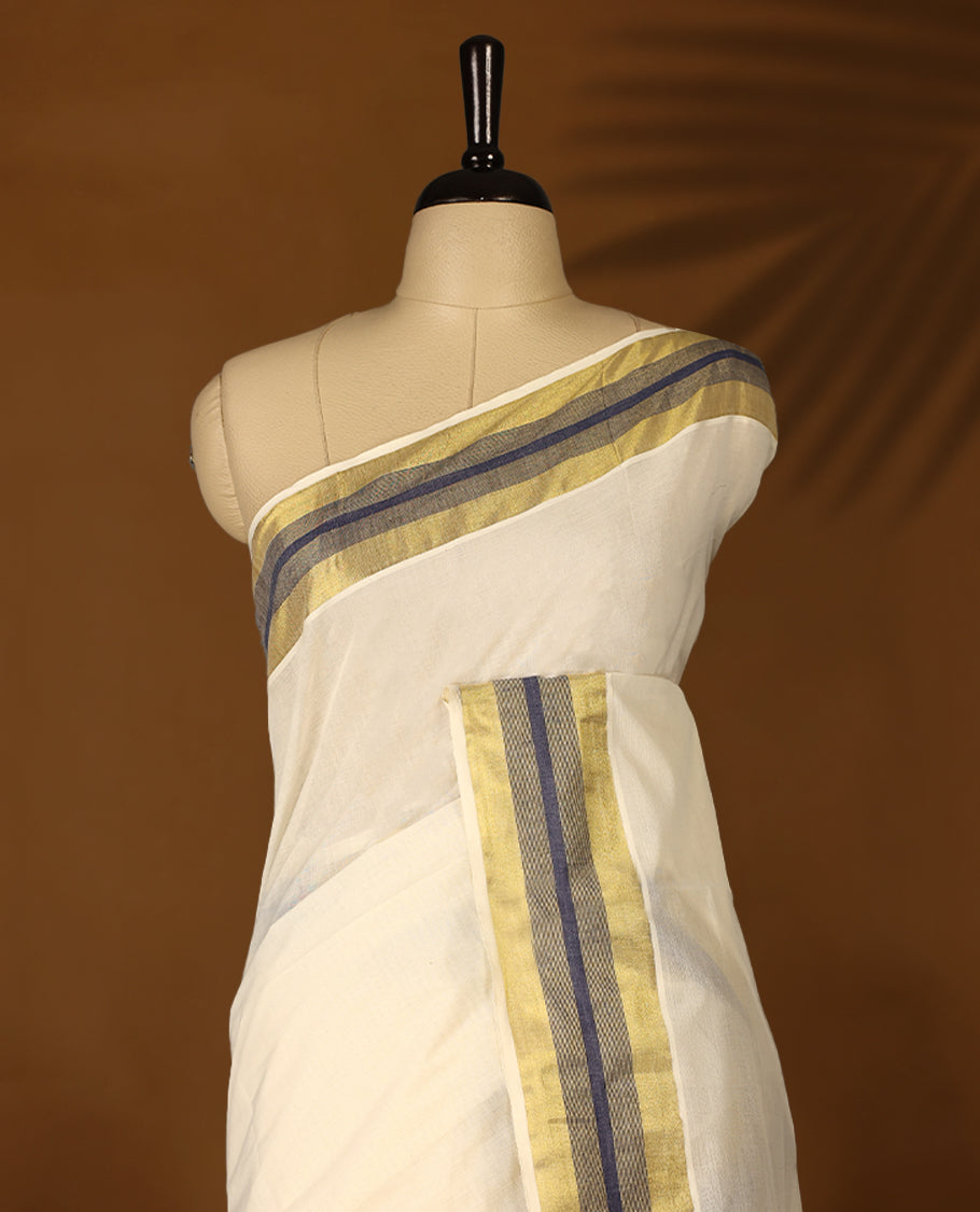 Elegant off white colour cotton Kerala saree featuring Plain body, Navy Blue colour & golden zari kasavu border offering a classic and graceful look, paired with a matching blouse.
