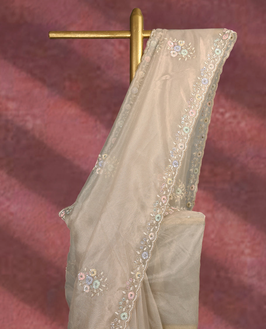 Deep beige colour pure organza saree featuring all over floral sequin work, adorned with a matching intricately worked floral border, complemented by a richly embellished pallu and paired with a heavily worked matching blouse.
