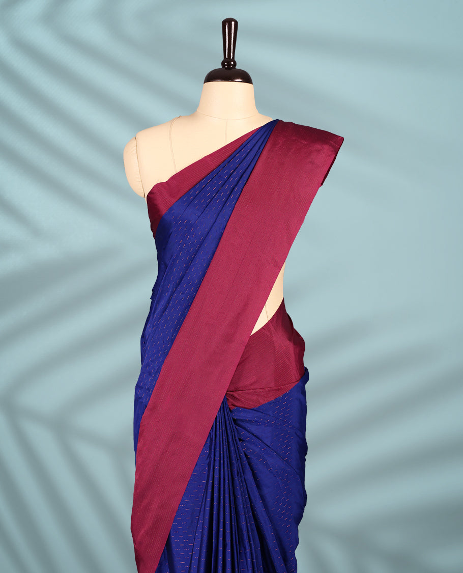 Royal blue Colour semi silk saree is adorned with a subtle copper zari pattern and beautifully offset by a rich wine border, paired with a matching blouse