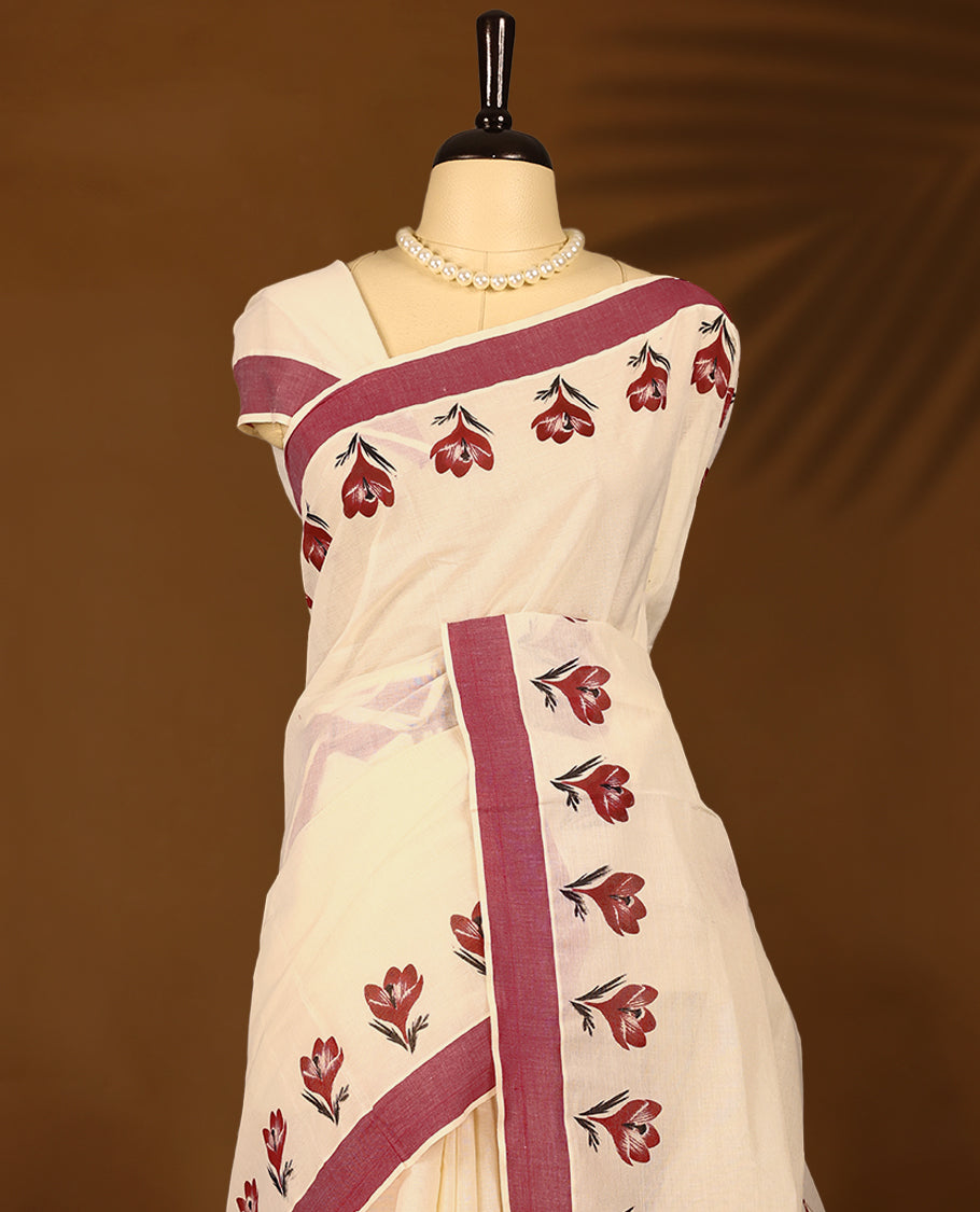 Kerala cotton saree showcases charming red floral Prints complemented by a deep maroon border with Matching Blouse