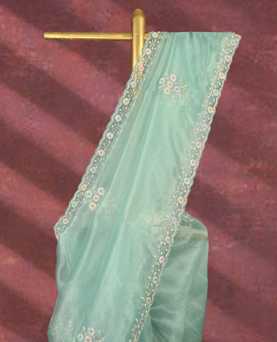 Aqua Green colour pure organza saree featuring all over floral sequin work, adorned with a matching intricately worked floral border, complemented by a richly embellished pallu and paired with a heavily worked matching blouse.