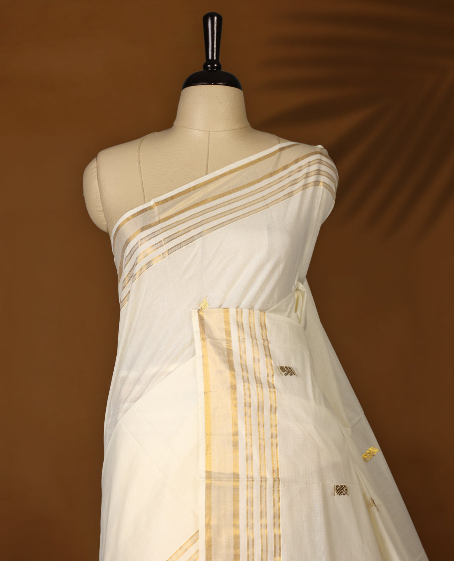 Elegant Off white colour cotton Kerala saree featuring Plain body, Gold zari fancy kazavu border, Rich Pallu paired with matching blouse.