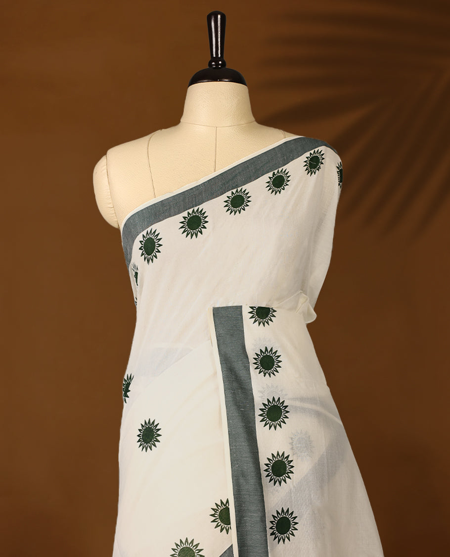 Elegant off white colour cotton Kerala saree featuring Plain body, Green colour border with Flower Block prints, Paired with matching blouse offering a classic and graceful look
