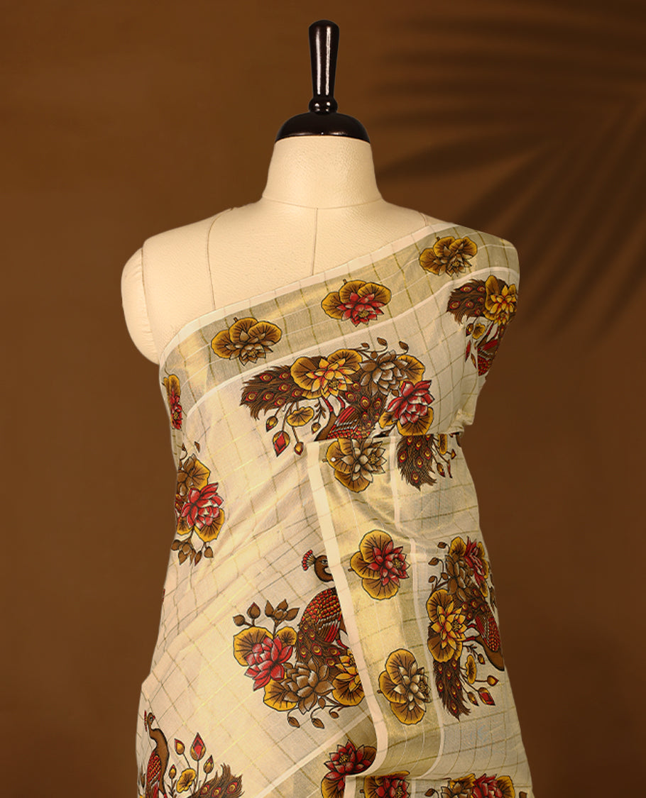 Light Gold colour Tissue Kerala saree featuring floral and peacock motifs on the body, golden zari checks, and a beautifully woven border with lotus Printed motifs, paired with a matching blouse perfect for festive occasions.