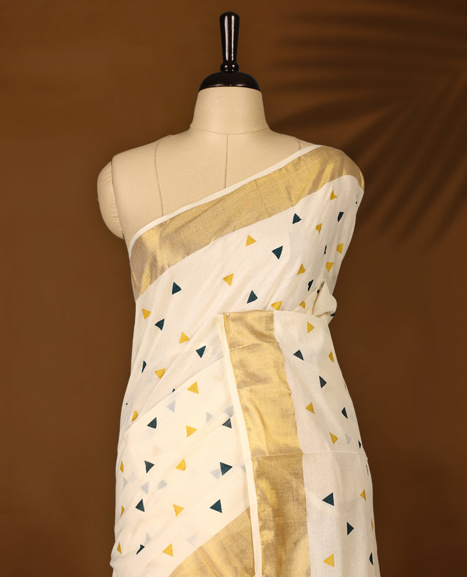 Elegant off white colour cotton Kerala saree featuring Midnight Blue and Gold Triangle prints on the body and traditional golden zari kasavu border offering a classic and graceful look, paired with a matching blouse.