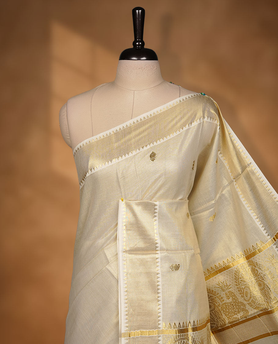 Elegant light gold tissue Kerala saree featuring delicate tree-inspired gold zari buttas across the body. Finished with a broad traditional kasavu border and a richly woven pallu, paired with a matching blouse