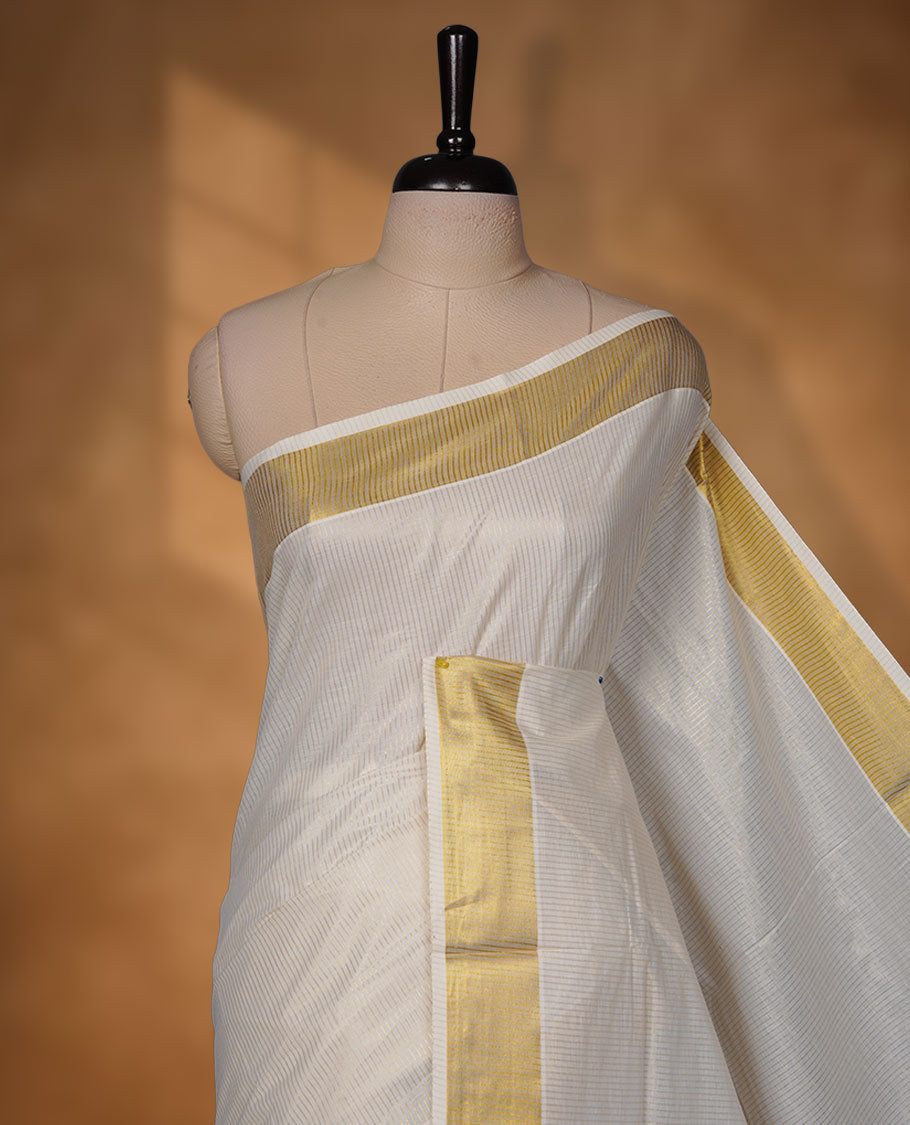 Off-white colour cotton Kerala saree crafted in a soft, sheer weave, finished with a classic rich gold kasavu border along the body and pallu, and paired with a matching blouse.