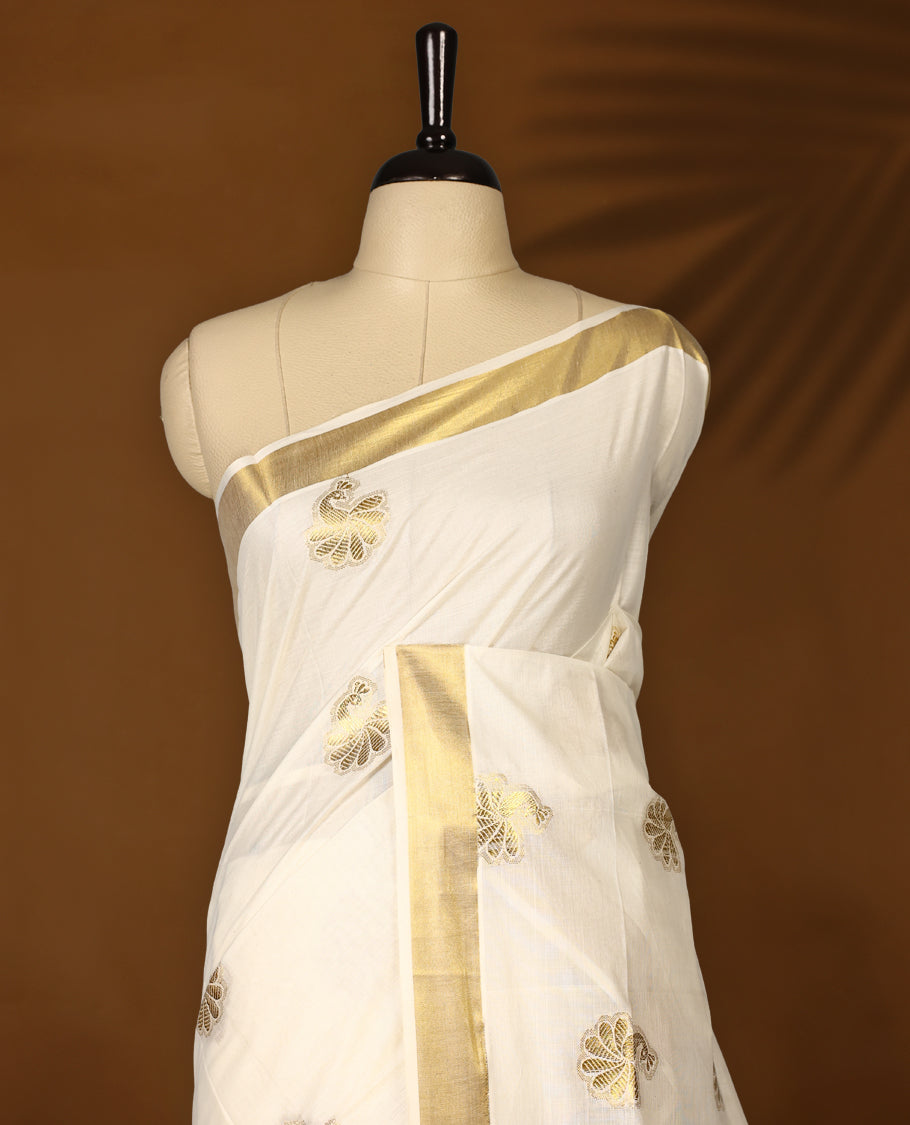 Elegant Off-white colour cotton Kerala saree with golden Peacock motifs on body, Gold zari kazavu border, Rich Pallu paired with matching blouse.