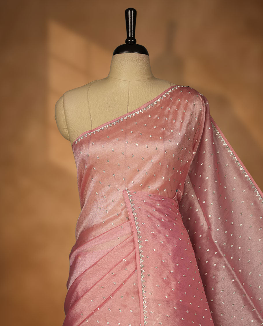 Dusty rose colour net shimmer fancy saree adorned with scattered white stone buttas, paired with a delicate stone worked border and matching blouse.