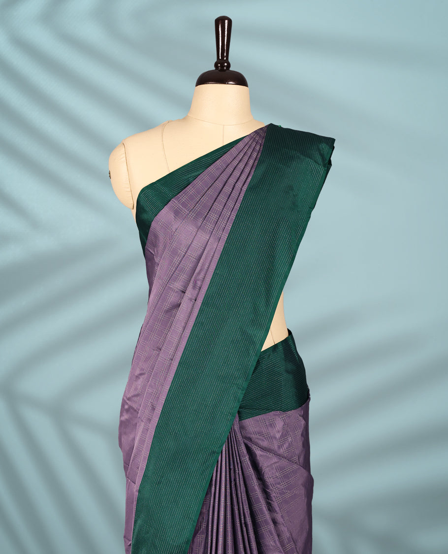 Pastel lavender Colour semi silk saree features a fine checked body design, contrasting deep green textured borders, and comes with a matching blouse.