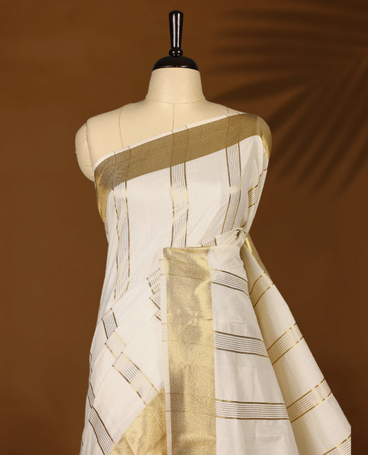 Elegant white colour sotf  Tussar Kerala saree featuring Bold Gold Zari stripes on body, Gold kasavu border, Rich Pallu, Paired with matching blouse offering a classic and graceful look