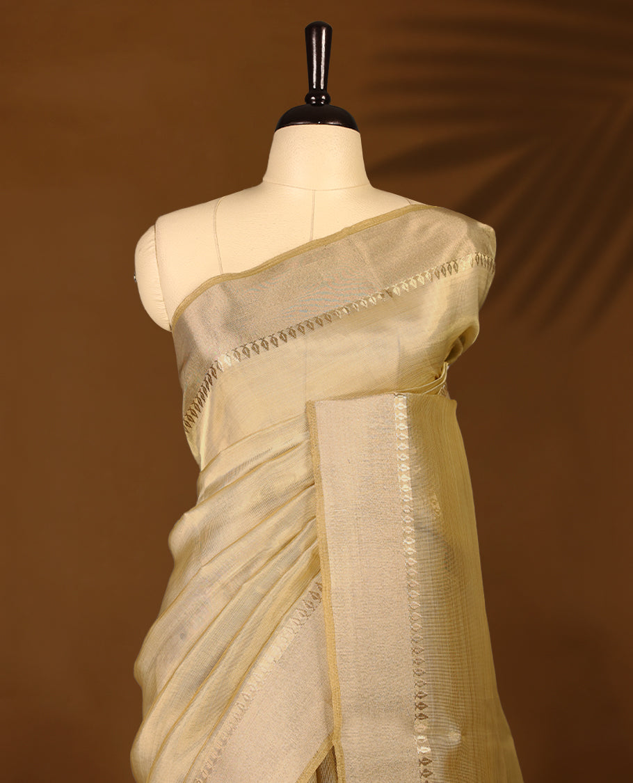 Elegant gold colour organza Kerala saree featuring a plain body, muted gold zari border, and a striking Gold Zari woven Bold pallu, paired with a matching blouse.