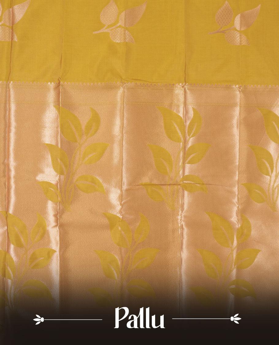 Mustard yellow colour semi silk saree adorned with elegant leaf motifs on the body, complemented by a shimmering golden zari woven pallu and border, and paired with a matching blouse