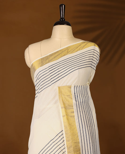 Elegant off white colour cotton Kerala saree featuring Blue colour Thread detailing on body, gold zari traditional kasavu border, Paired with matching blouse offering a classic and graceful look, paired with a matching blouse.