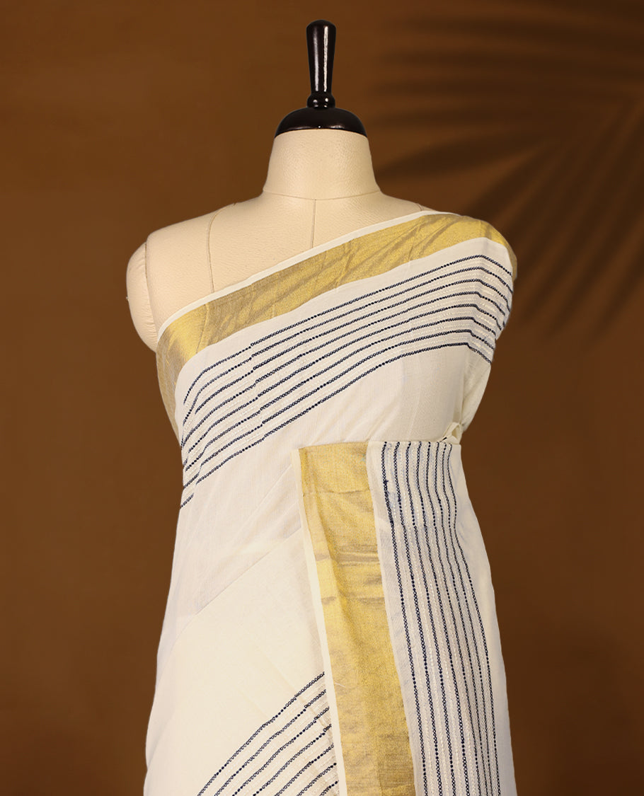 Elegant off white colour cotton Kerala saree featuring Blue colour Thread detailing on body, gold zari traditional kasavu border, Paired with matching blouse offering a classic and graceful look, paired with a matching blouse.
