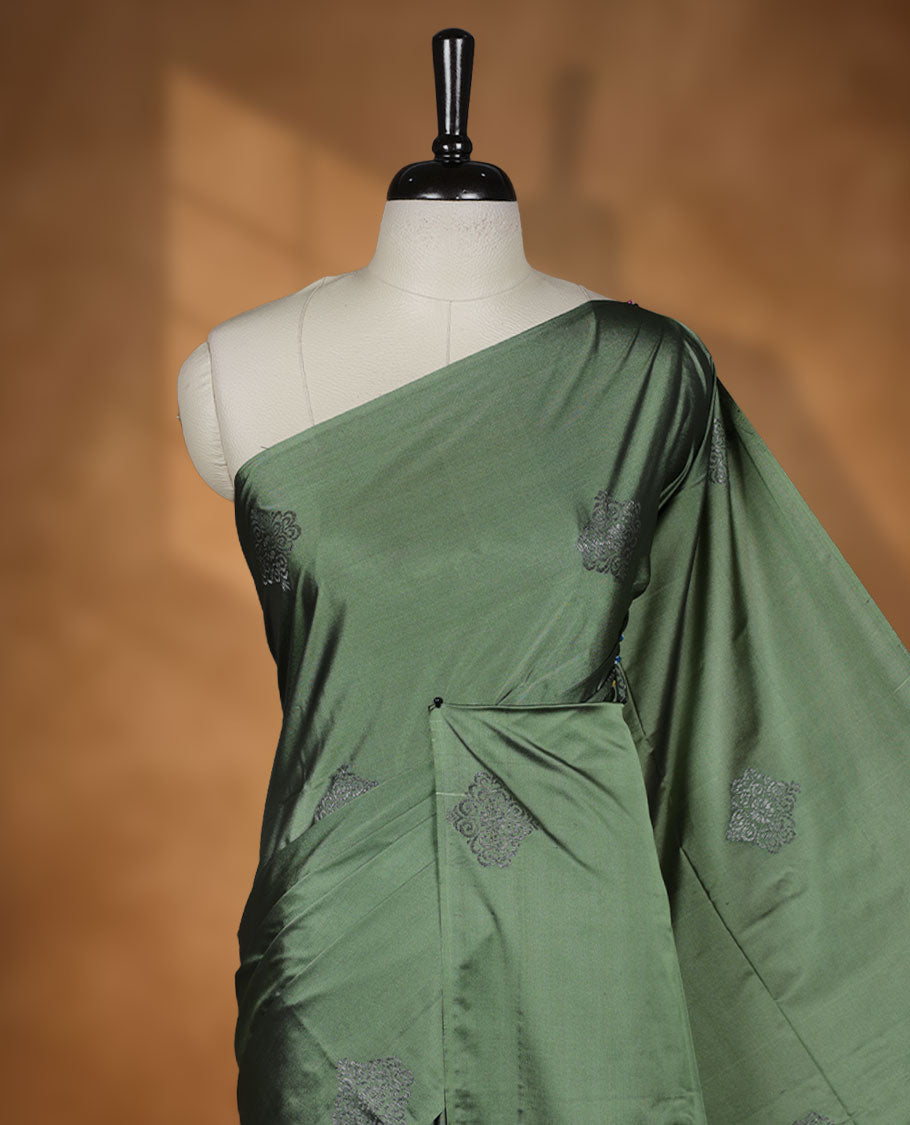 Maple green colour semi soft silk saree adorned with delicate woven motifs on the body, complemented by a Self colour woven pallu with intricate detailing and tassel accents without border & Comes with a matching blouse piece.
