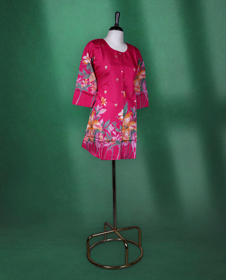 Fuchsia pink colour short kurti featuring a round neck and three quarter sleeves, adorned with vivid orange floral prints and minimal front buttons for a vibrant, breezy look.