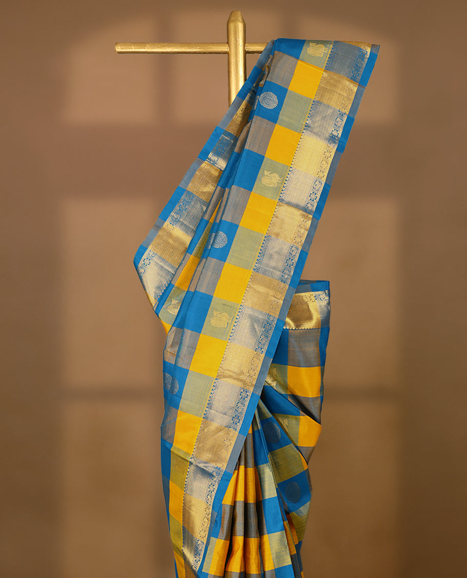 Blue and yellow Checked pure traditional Kancheepuram silk saree featuring antique zari peacock and chakkram motifs on the body, complemented by a traditional border adorned with peacock and diamond motifs, and paired with a matching blouse.