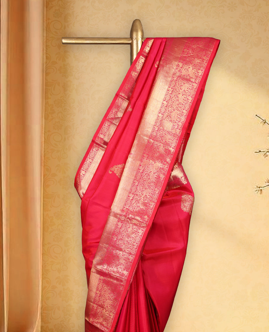 Rani pink colour pure Kancheepuram saree with gold zari Banarasi paisley mango motifs on the body traditional border with elephant peacock and chackram pattern grand pallu with floral chackara motifs paired with matching blouse