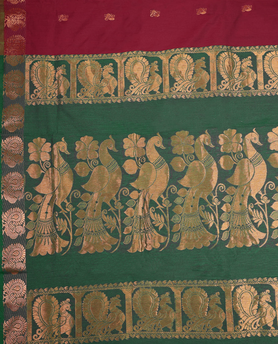 Maroon and Bottle Green Kalyani cotton saree adorned with traditional peacock motifs, enhanced by a rich woven zari border and pallu in green, paired with a matching blouse.