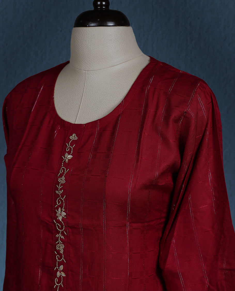 Maroon colour kurti with subtle vertical self stripes, adorned with delicate golden thread embroidery along the front placket, featuring a round neckline and stylish three quarter sleeves.