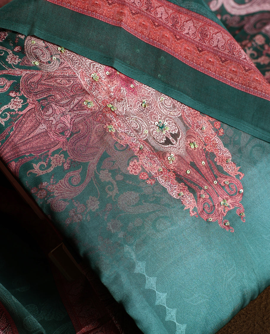 Dark green colour churidhar material featuring intricate embroidery with subtle paisley patterns, paired with a richly printed dupatta and plain bottom.