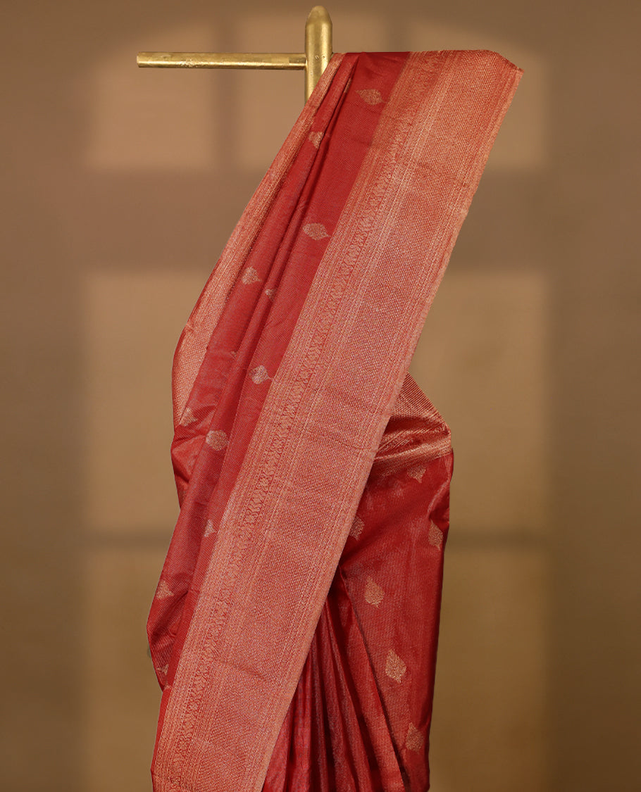 Red Colour Manthrakodi saree featuring tissue weaving with traditional motifs on the body, complemented by a self coloured traditional border and a matching self coloured blouse.