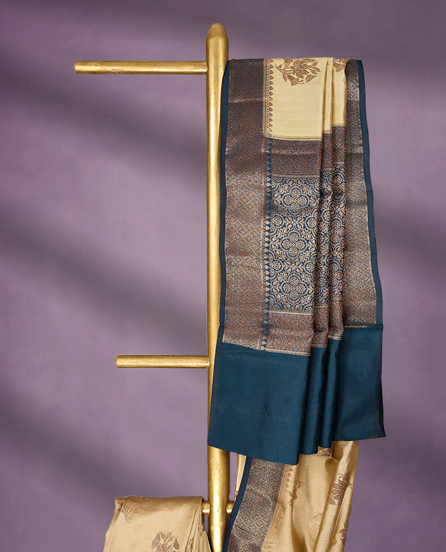 Beige Colour Pure Banaras Soft Silk Saree adorned with traditional antique zari motifs, paired with a hand dyed German Blue antique style border and a matching blouse.