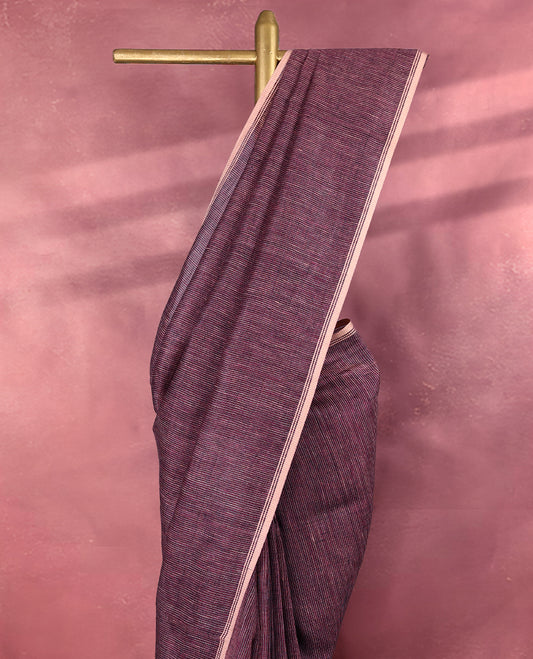 Grape wine colour pure linen saree featuring fine beige thread stripes running throughout the body, accented with a soft beige border and pairs gracefully with a matching blouse.