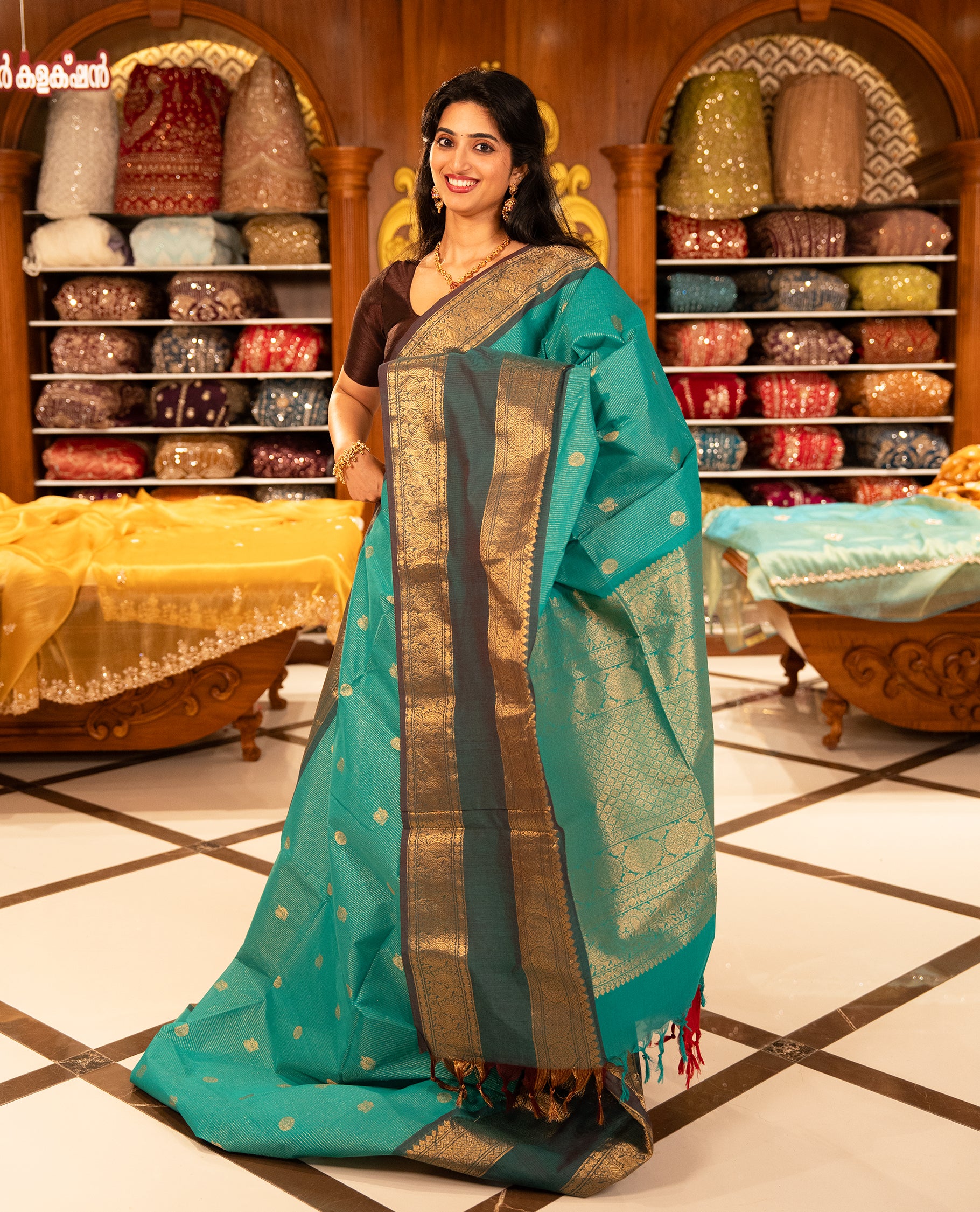 Aqua with Brown colour Chettinad cotton saree featuring Gold zari strips with peacock motifs on body, complemented by contrast colour border with zari design & grand pallu, comes with matching blouse piece.