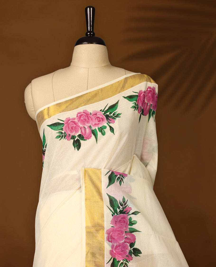 Graceful off white colour Kerala cotton saree with bold pink floral prints and a golden zari border, Lightweight and elegant, it comes with a matching blouse & perfect for festive and semi-formal occasions.