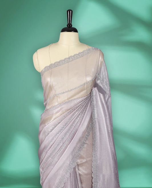 Light Pastel Pink colour net shimmer fancy saree adorned with subtle horizontal White stone patterns on the body, paired with a delicate stone worked border, with matching blouse