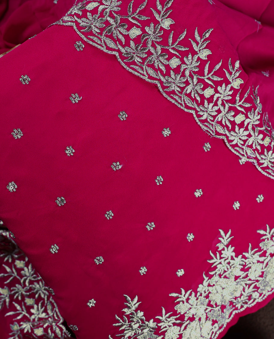 Pinkish red colour churidhar material adorned with elegant golden floral embroidery and delicate motifs, paired with a matching embroidered dupatta and plain bottom.