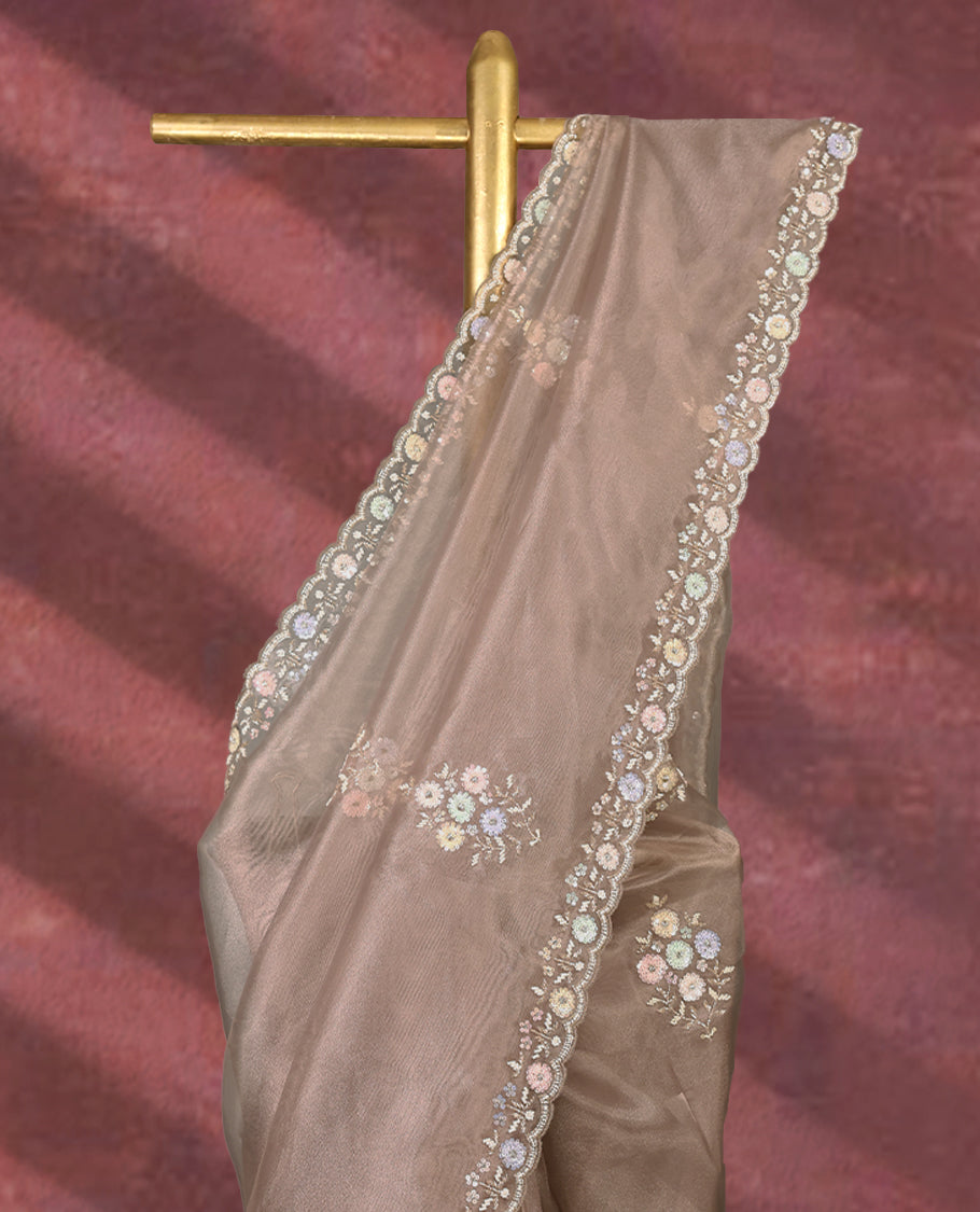 Pastel taupe colour pure organza saree featuring all over floral sequin work, adorned with a matching intricately worked floral border, complemented by a richly embellished pallu and paired with a heavily worked matching blouse.