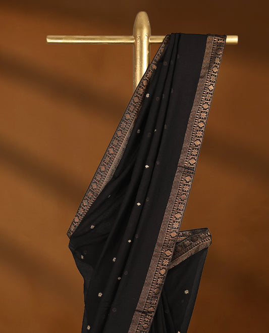 Black colour soft khadi cotton saree with small Beige Zari Flower motifs on the body, detailed woven Gold zari border, paired pallu with tussles, with matching blouse.