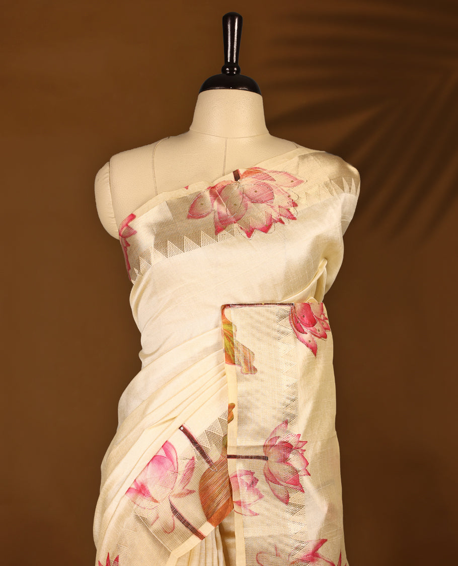 Off white colour Kerala saree crafted in soft tussar, adorned with vibrant pink lotus floral prints with thread and sequence work on the body and pallu, enhanced by a subtle golden zari border, Paired with a matching blouse.