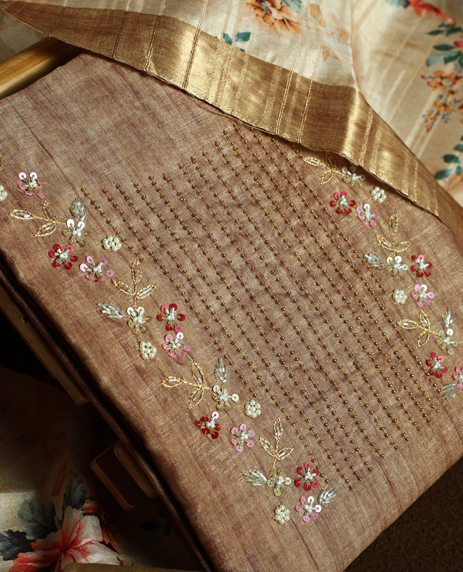 Flaxen yellow colour churidhar material adorned with floral embroidery and sewn glass beads on the yoke, paired with a plain bottom and same colour dupatta featuring floral prints.