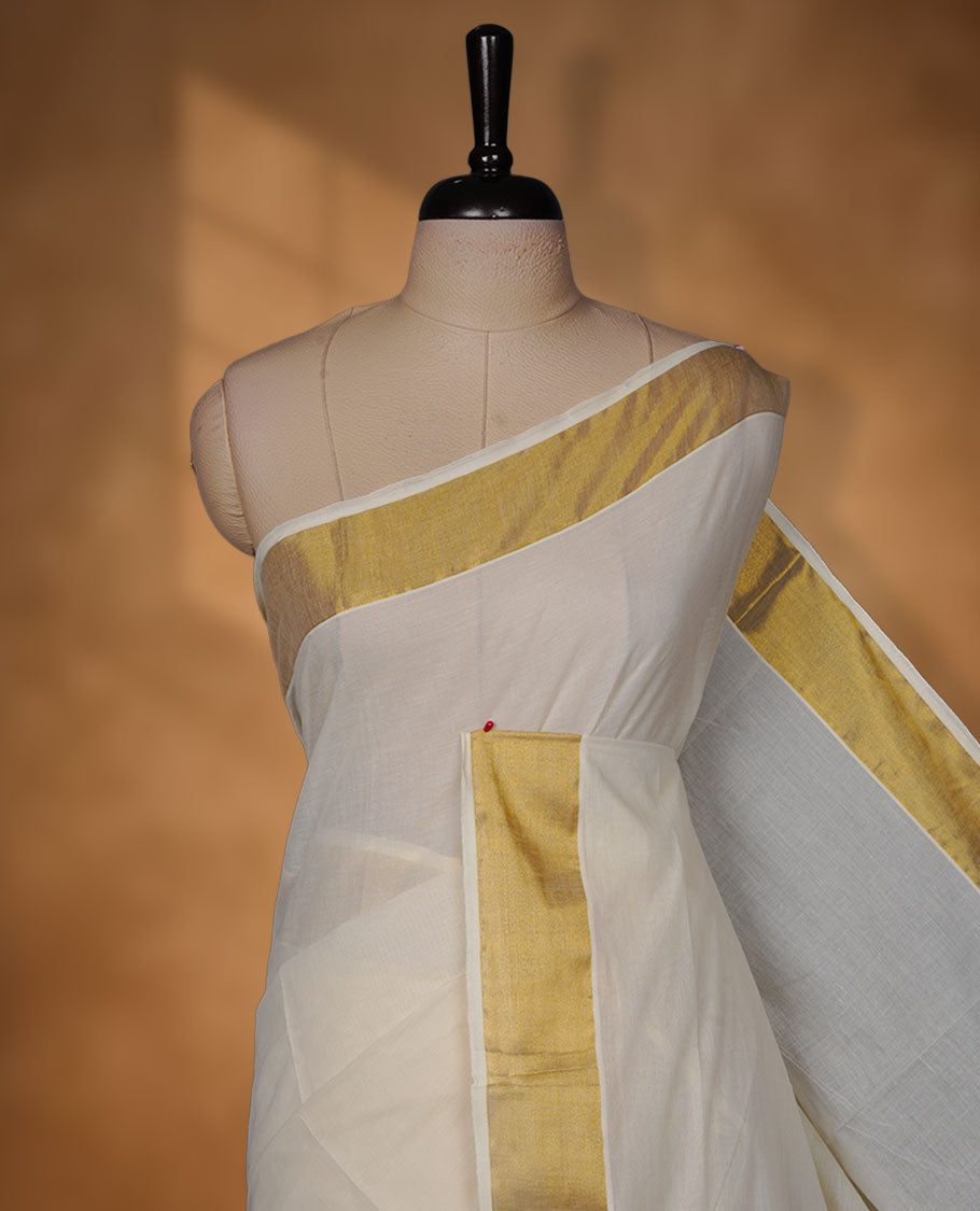Off-white colour cotton Kerala saree crafted in a soft, sheer weave, finished with a rich gold kasavu border along the body and pallu, and paired with a matching blouse.